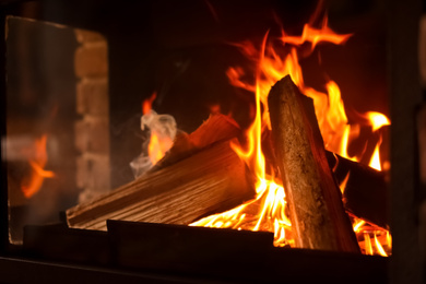 Photo of Fireplace with burning wood, closeup view. Winter vacation