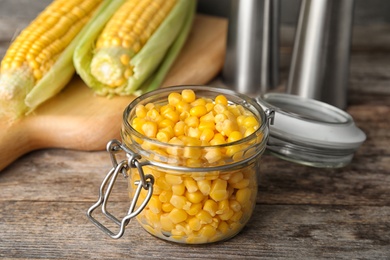 Photo of Jar with corn kernels on wooden table