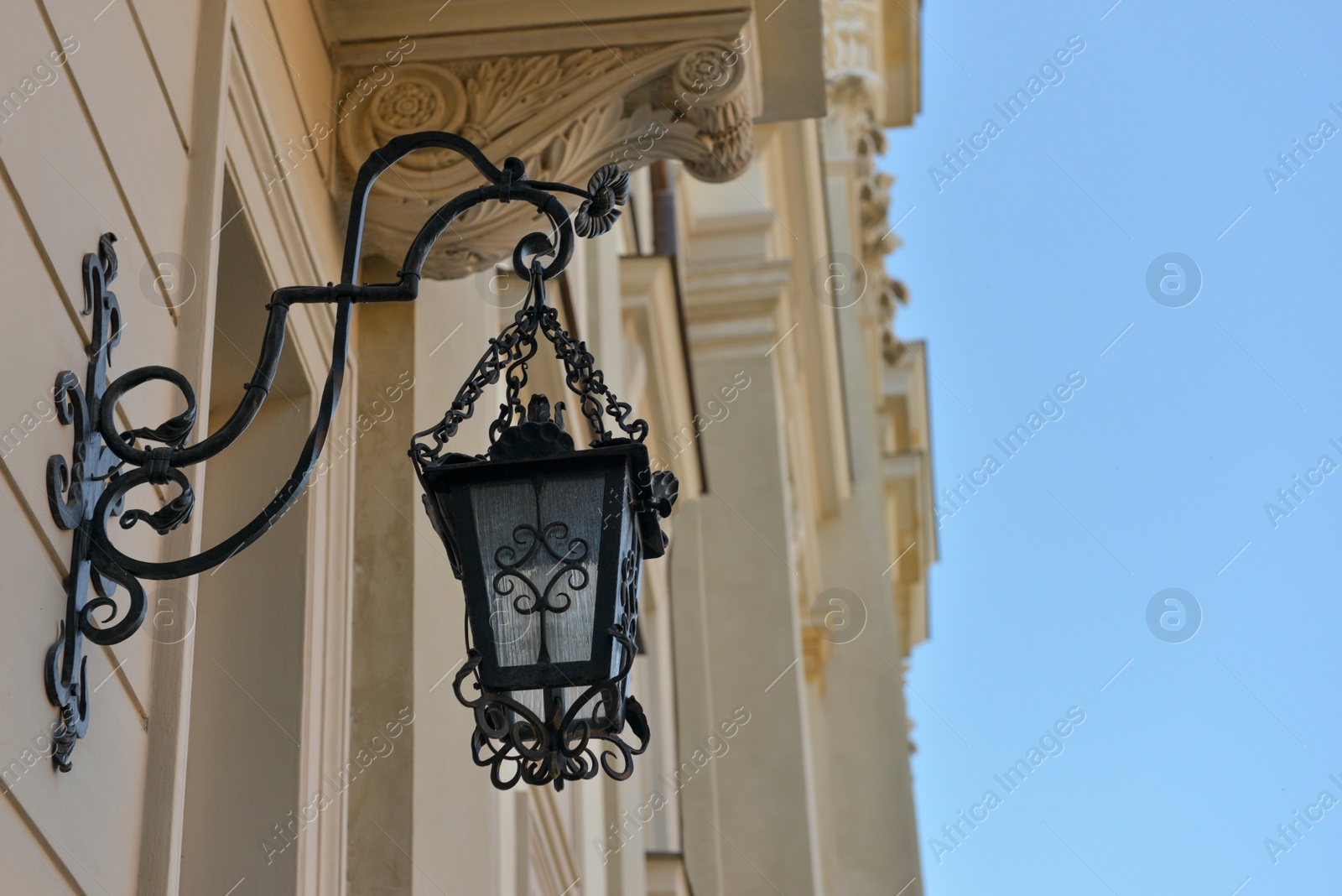 Photo of Beautiful vintage street lamp hanging on wall of building