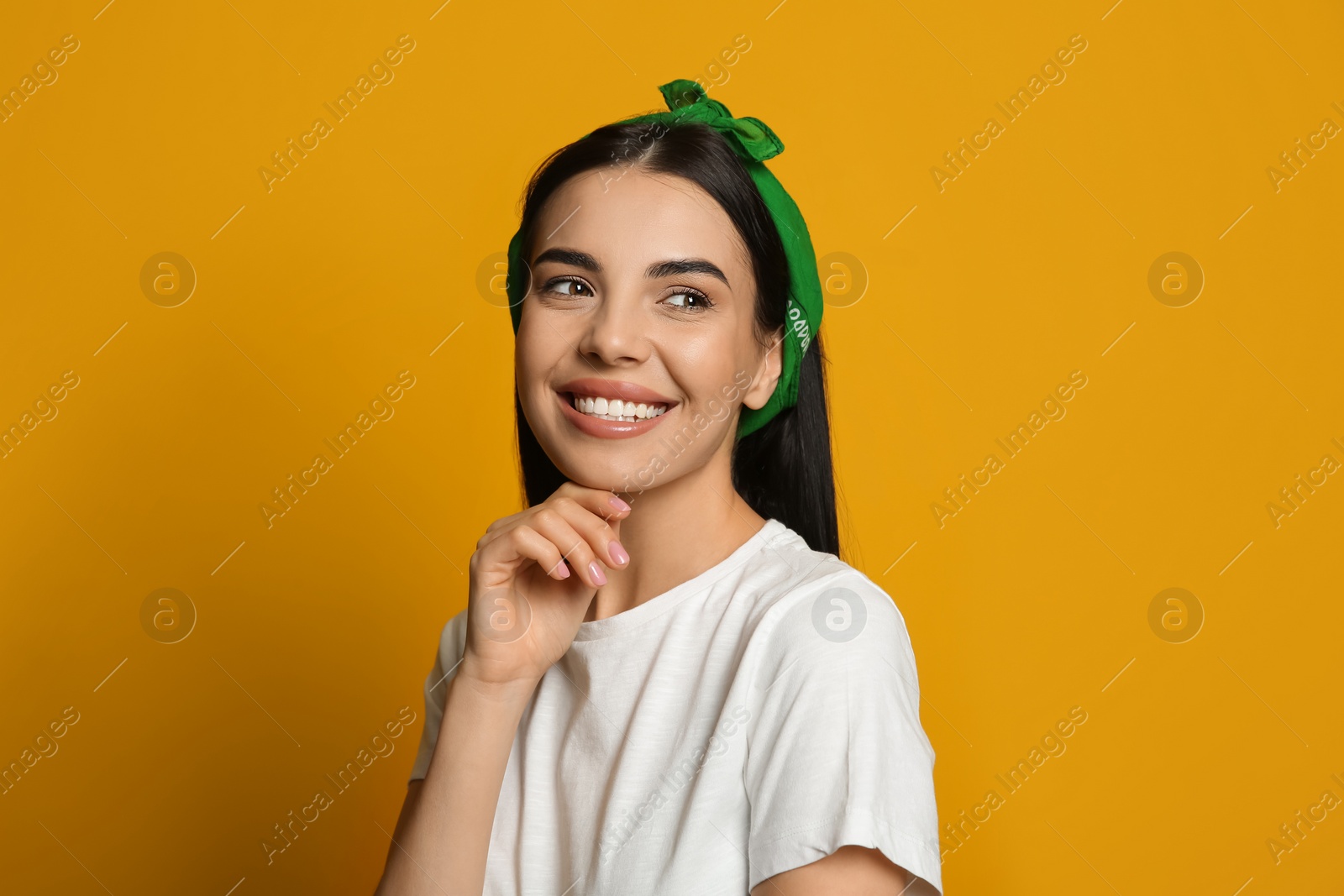 Photo of Young woman wearing stylish bandana on orange background