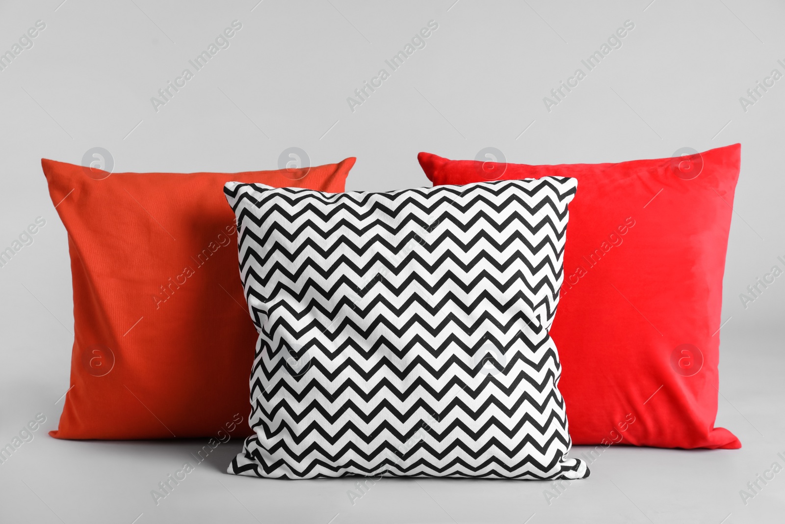 Photo of Different stylish soft pillows on grey background