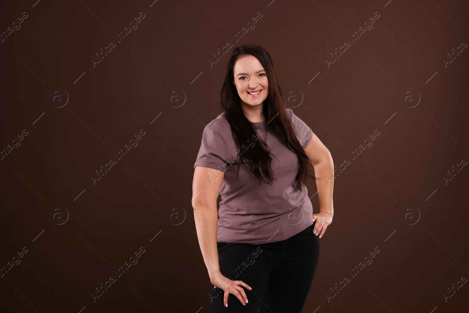 Photo of Beautiful overweight woman with charming smile on brown background