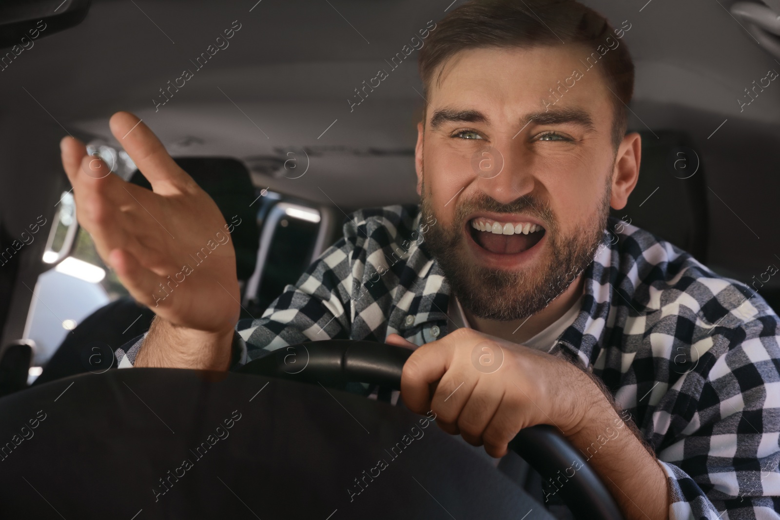 Photo of Emotional man in car. Aggressive driving behavior