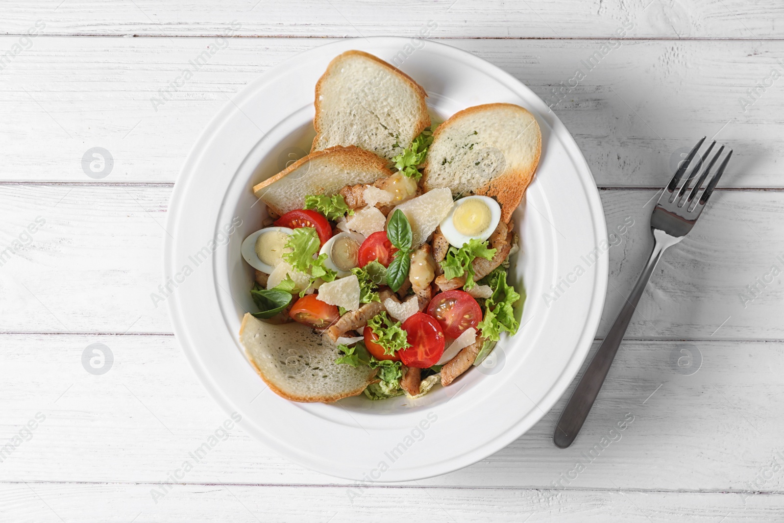 Photo of Plate with delicious fresh salad on table, top view