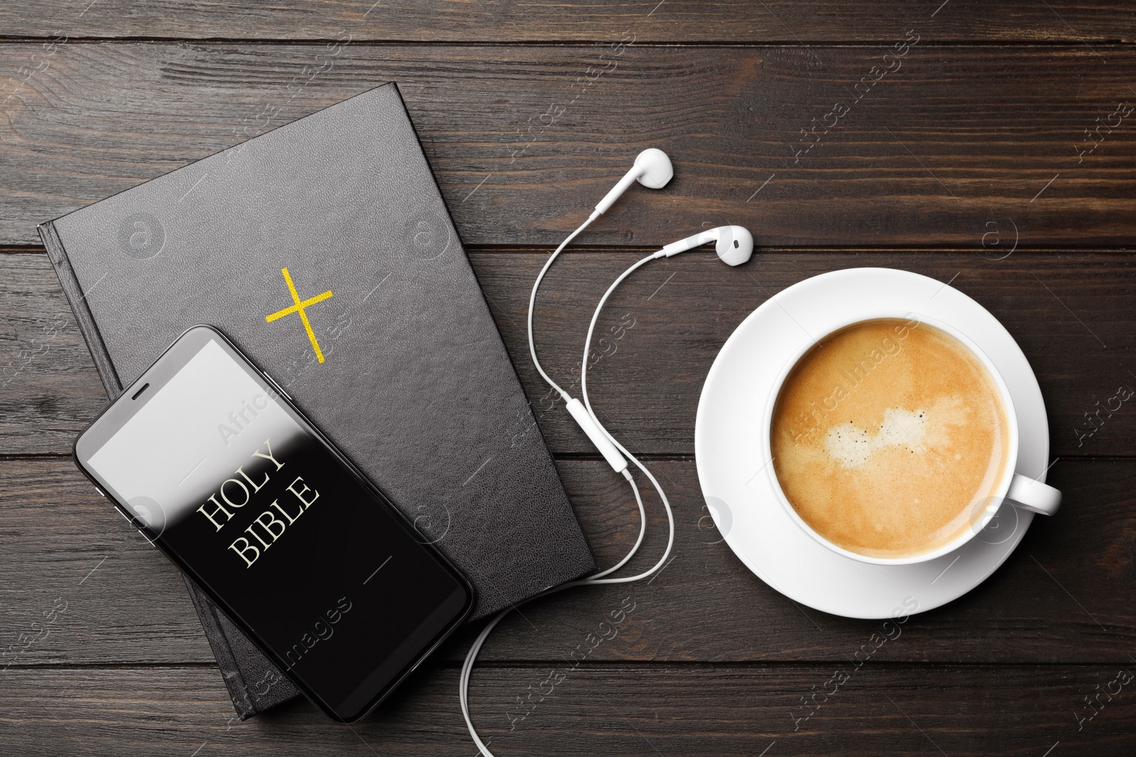 Photo of Bible, phone, cup of coffee and earphones on wooden background, flat lay. Religious audiobook