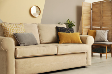 Photo of Modern comfortable sofa with pillows indoors. Stylish room interior