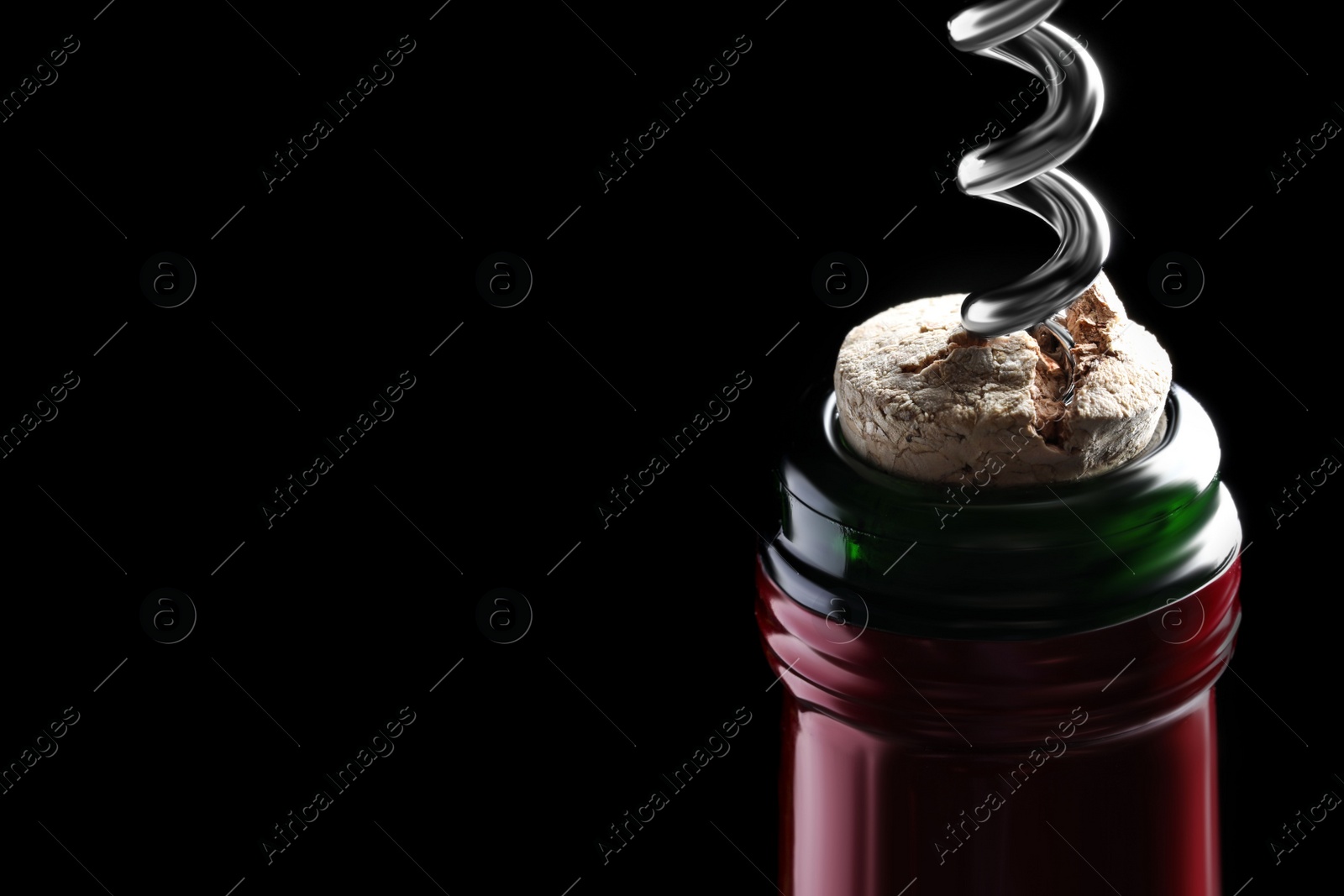 Photo of Opening wine bottle with corkscrew on dark background, closeup. Space for text