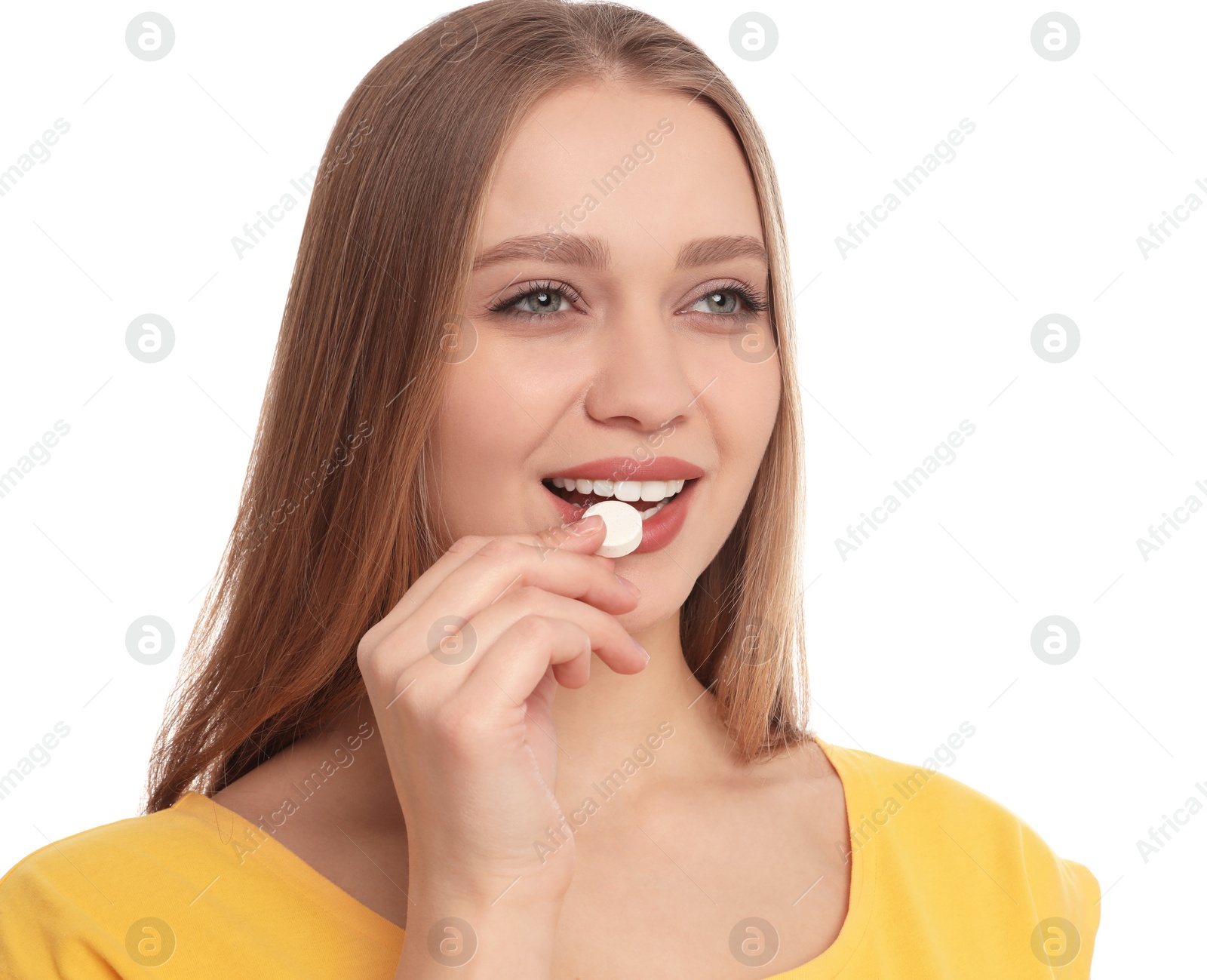 Photo of Young woman taking vitamin pill on white background