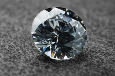 Photo of Beautiful shiny diamond on grey background, closeup