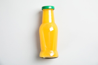 Photo of One bottle with tasty drink on color background, top view