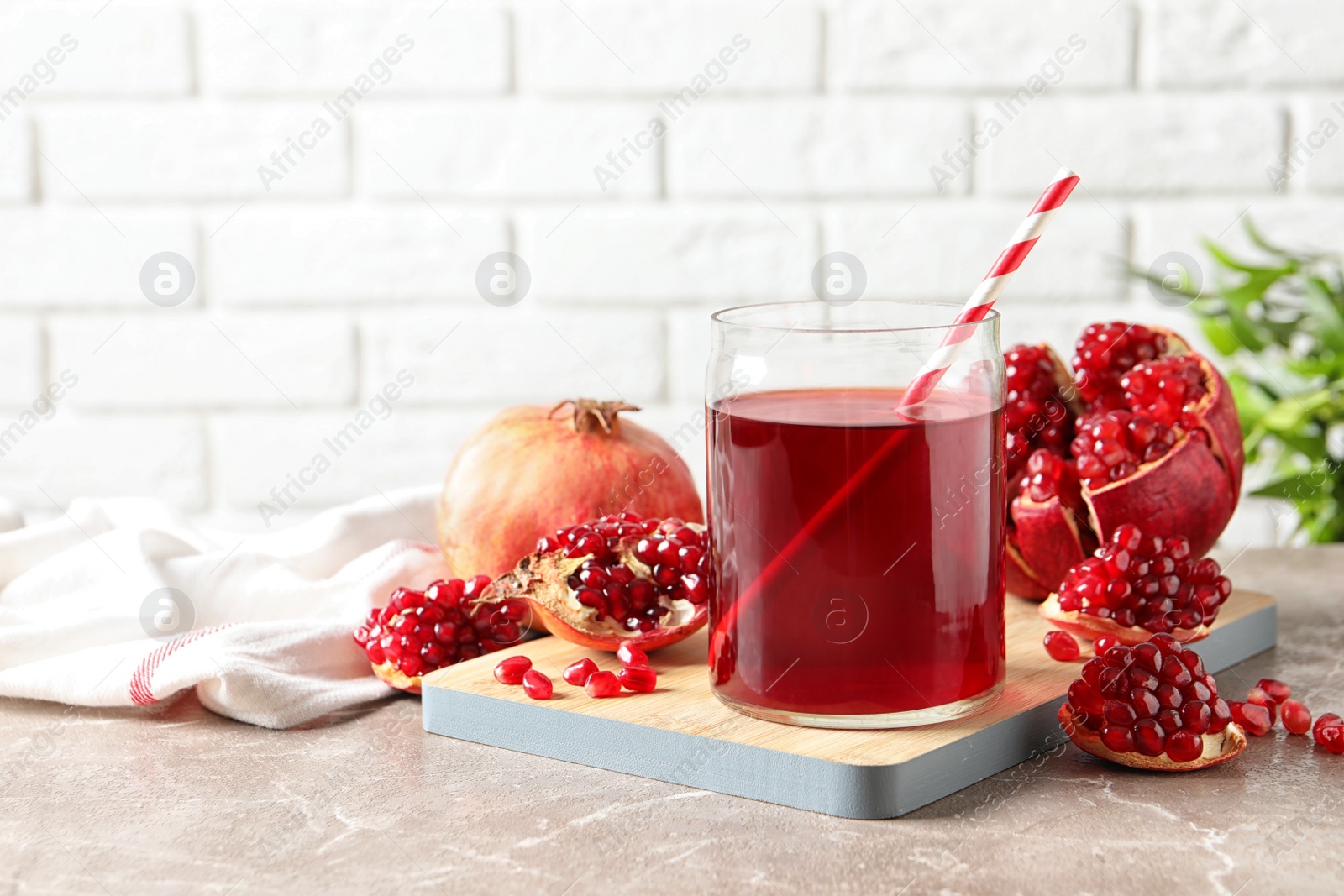 Photo of Composition with glass of fresh pomegranate juice on table. Space for text