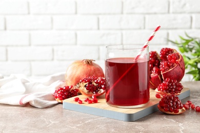 Photo of Composition with glass of fresh pomegranate juice on table. Space for text