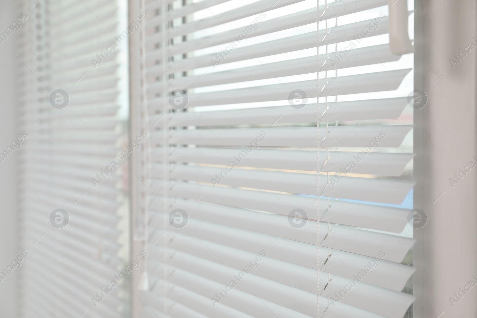 Photo of Stylish window with horizontal blinds in room, closeup