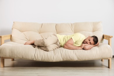 Photo of Tired man sleeping on sofa at home