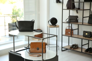 Photo of Stylish woman's bags on stand in boutique