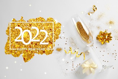 Image of Happy New 2022 Year! Glass with gold glitter and gift box on white background, flat lay