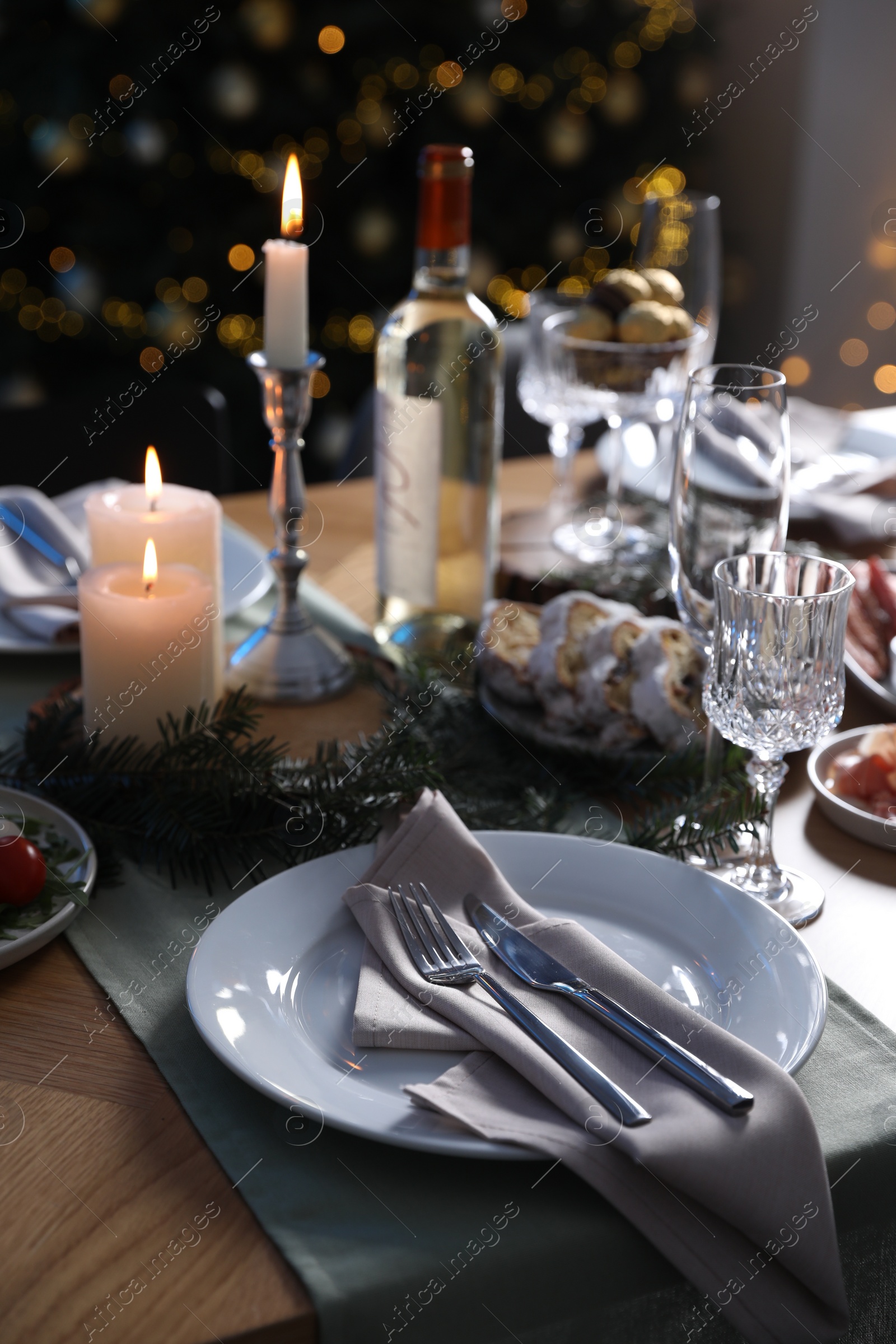 Photo of Christmas table setting with festive decor and dishware indoors