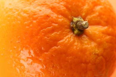 Photo of Delicious unpeeled orange with water drops as background, closeup