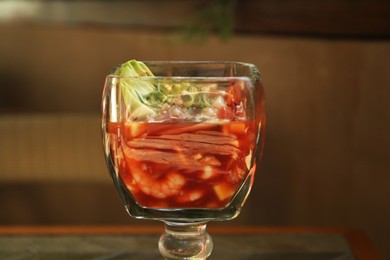 Photo of Delicious campechana cocktail with shrimps on table, closeup