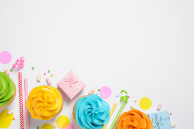 Photo of Flat lay composition with colorful birthday cupcakes on white background. Space for text