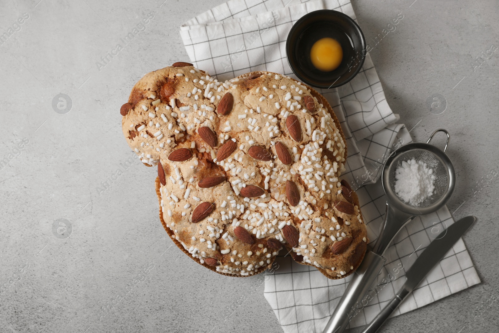 Photo of Delicious Italian Easter dove cake (Colomba di Pasqua) on grey table, flat lay. Space for text