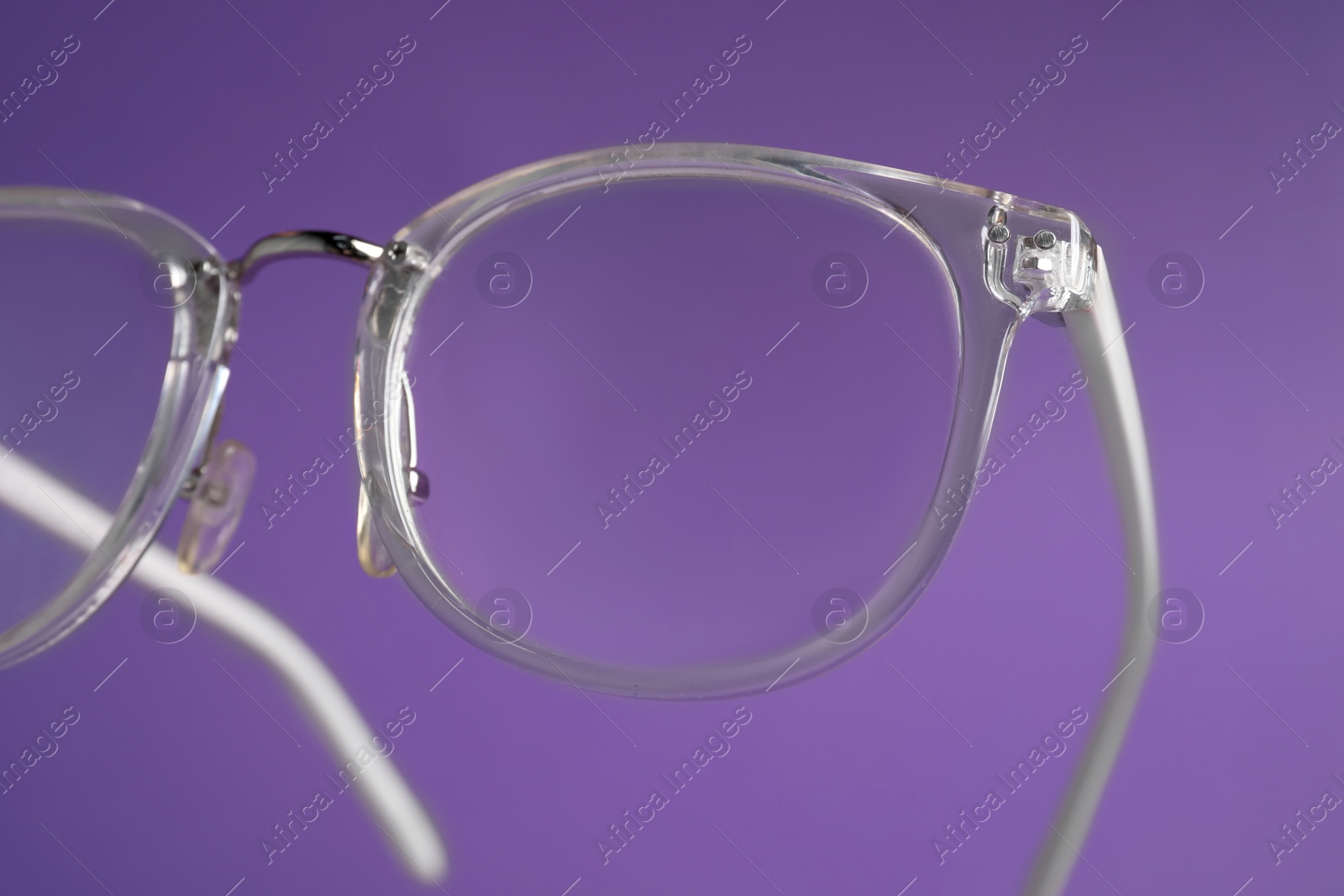 Photo of Stylish pair of glasses on purple background, closeup