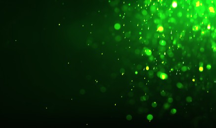 Image of St. Patrick day. Shiny green glitter on black background, bokeh effect