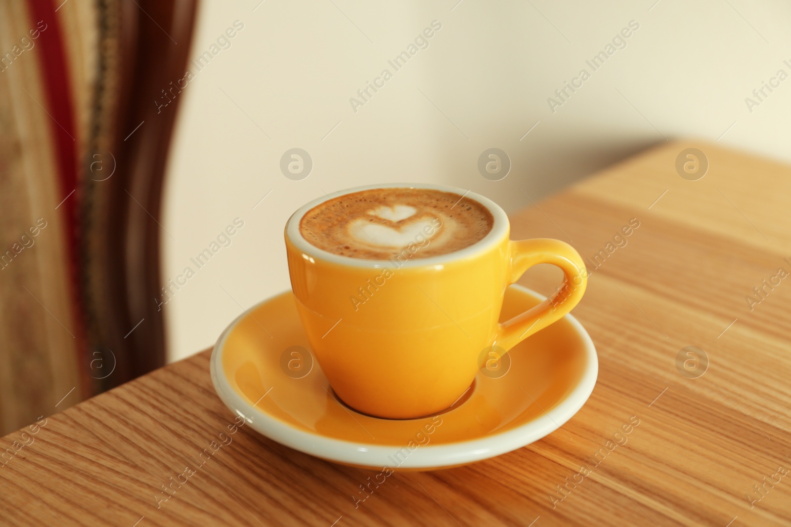 Photo of Cup of delicious coffee on wooden table indoors