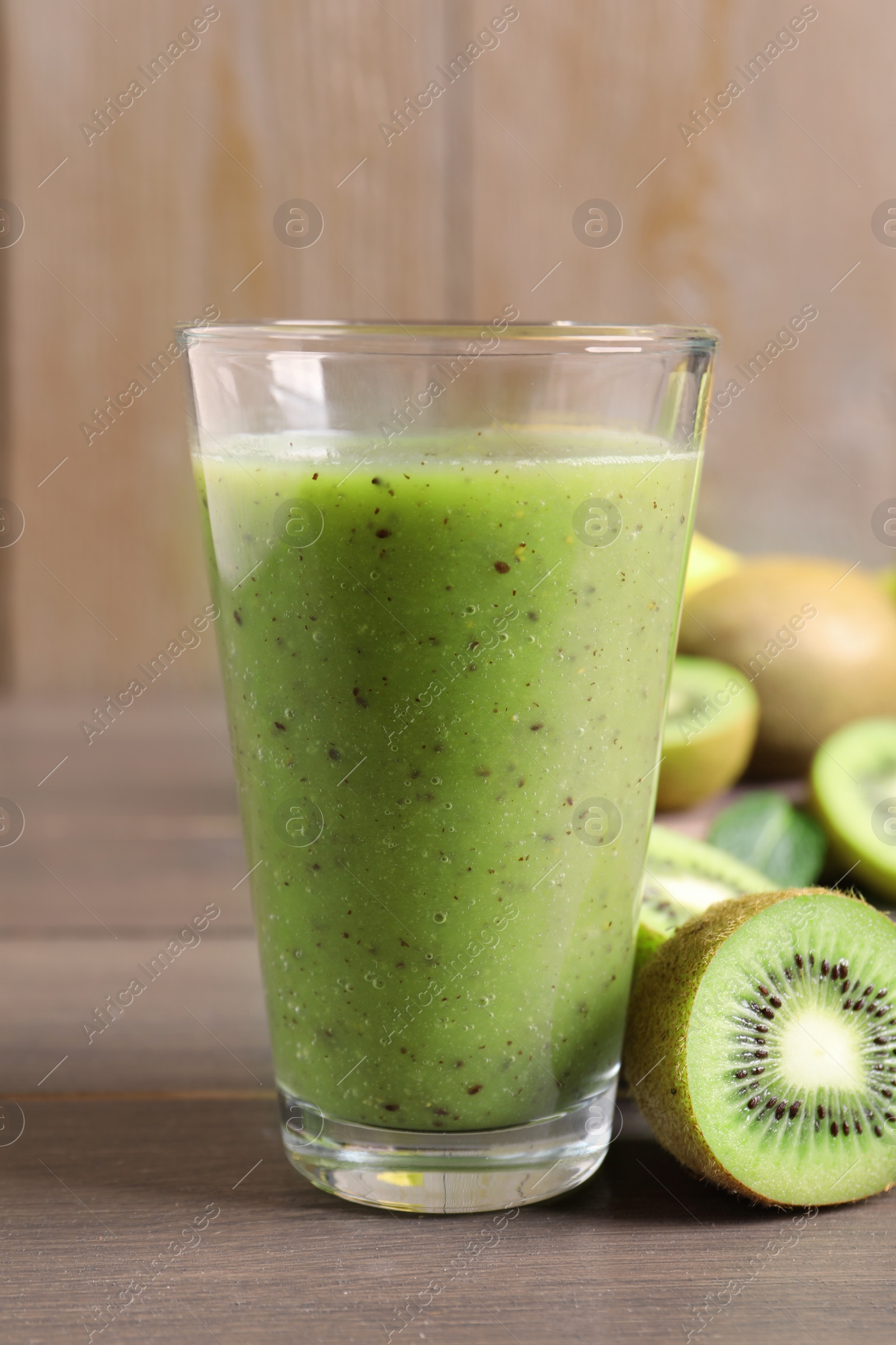 Photo of Delicious kiwi smoothie and fresh fruits on wooden table