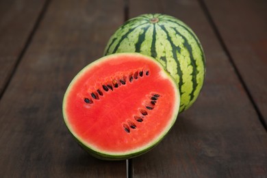 Delicious cut and whole ripe watermelons on wooden table