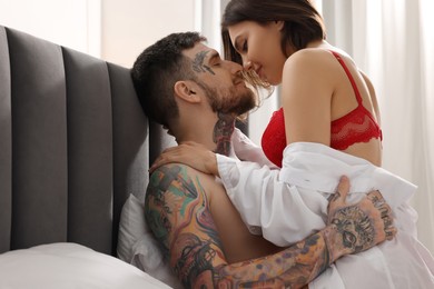 Passionate couple having sex on bed at home