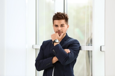 Photo of Portrait of handsome young man near window