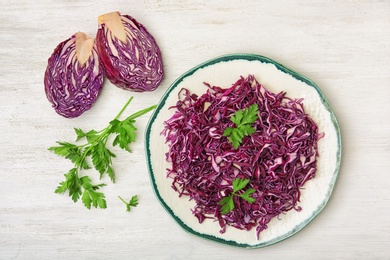 Flat lay composition with chopped purple cabbage and parsley on wooden background