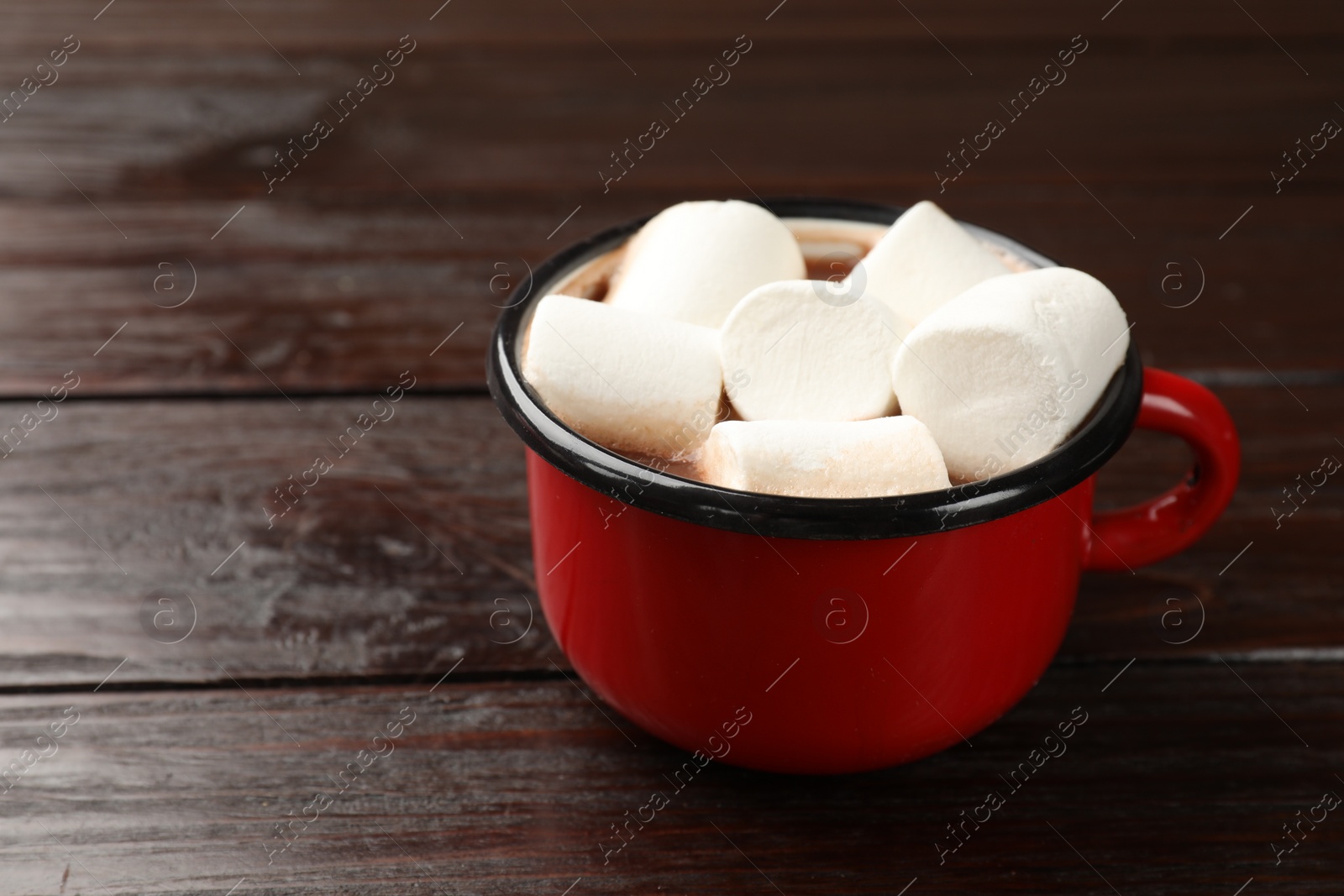 Photo of Tasty hot chocolate with marshmallows on wooden table, closeup. Space for text