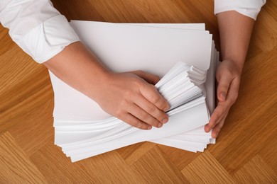 Photo of Man stacking documents at wooden table, top view