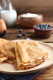 Photo of Delicious crepes served on wooden table, closeup. Space for text