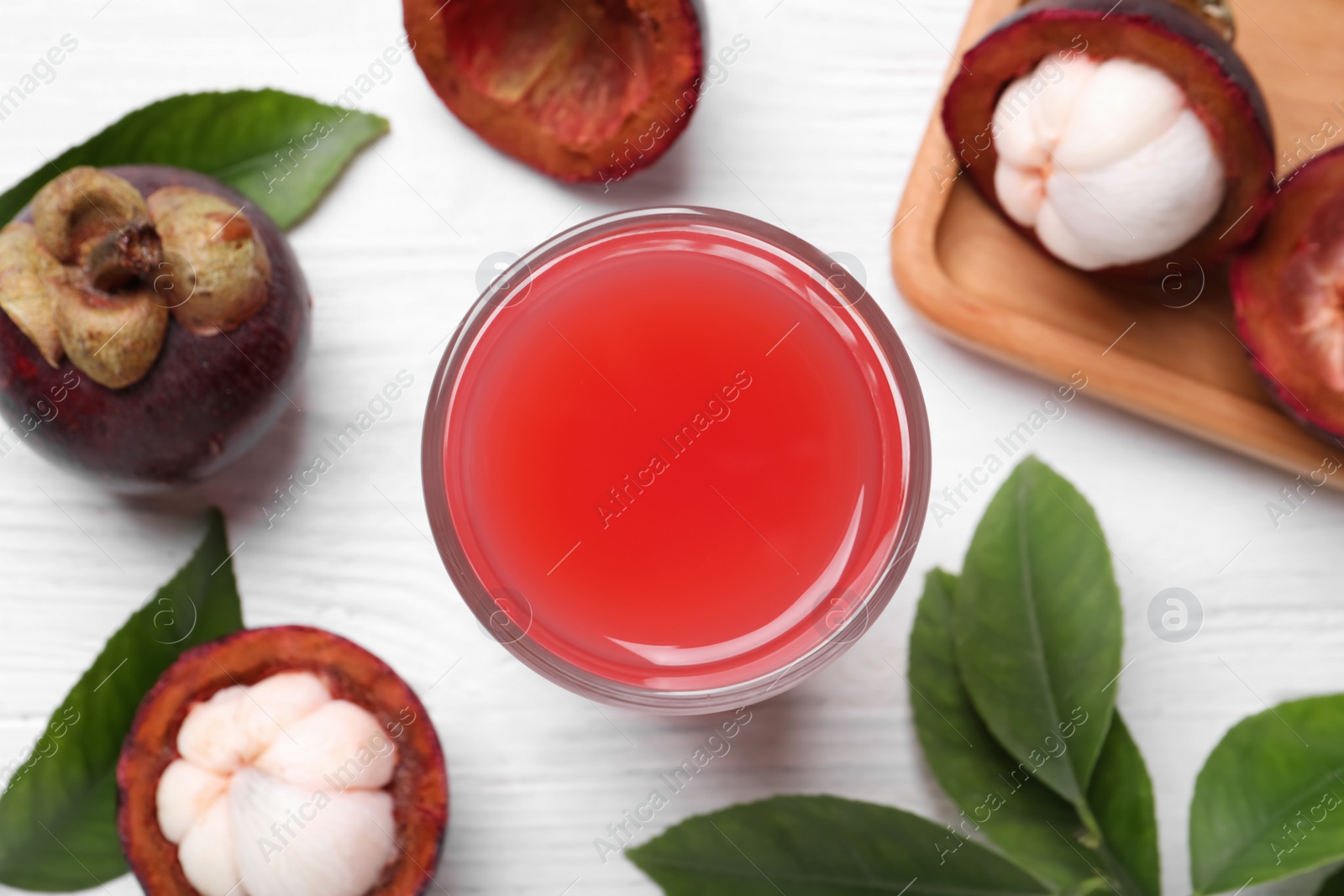 Photo of Delicious fresh mangosteen juice on white table, flat lay. Space for text