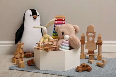Photo of Set of different toys on floor near beige wall