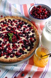 Photo of Delicious currant pie and fresh berries on kitchen towel