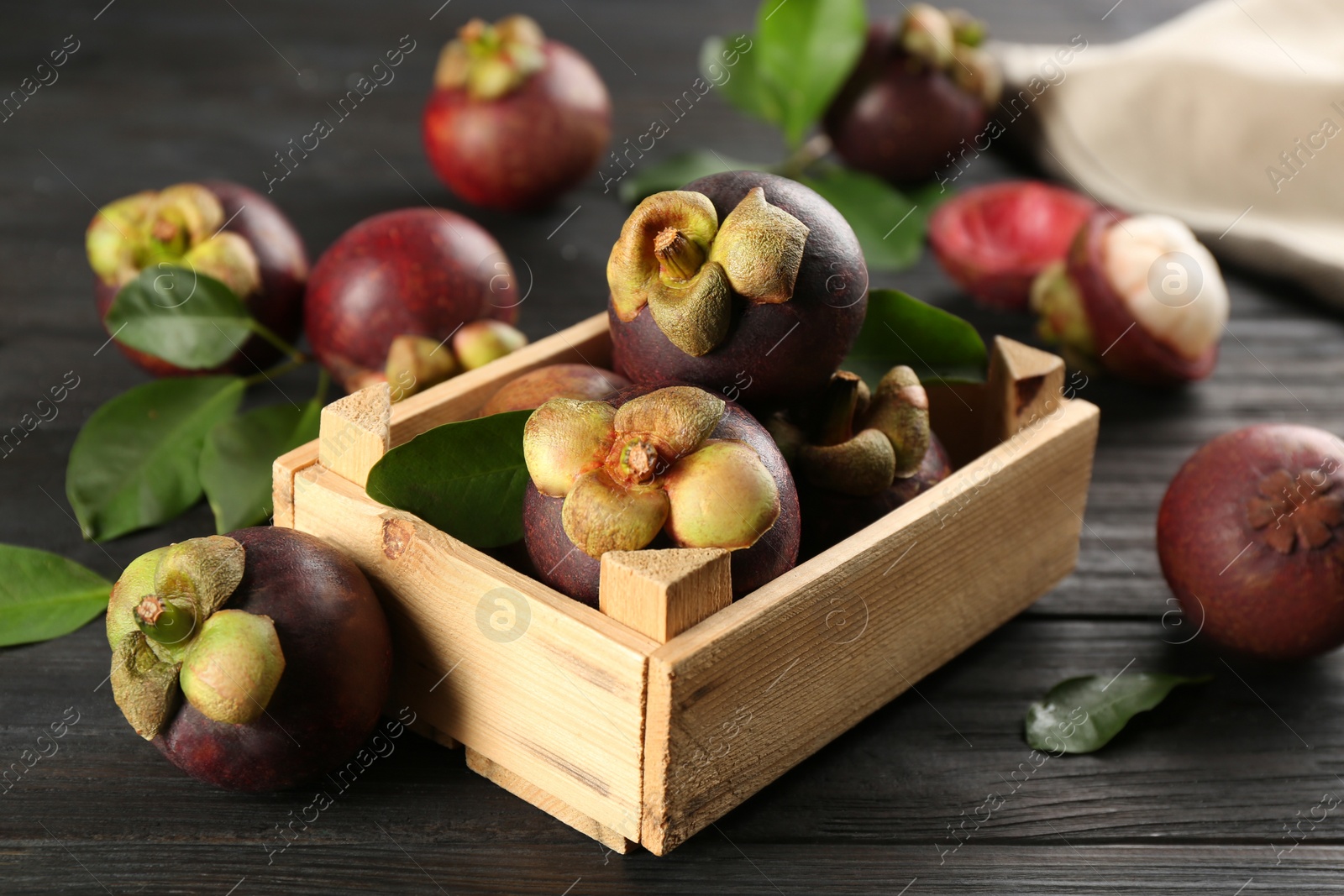 Photo of Fresh ripe mangosteen fruits on dark wooden table