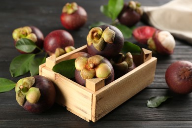 Photo of Fresh ripe mangosteen fruits on dark wooden table