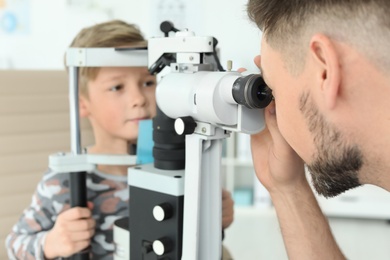 Ophthalmologist examining little boy in clinic