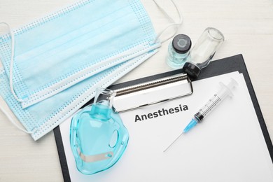 Flat lay composition of clipboard with word Anesthesia and medical equipment on white wooden table