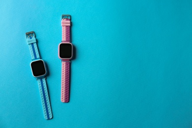 Photo of Kid smart watches on light blue background, flat lay. Space for text