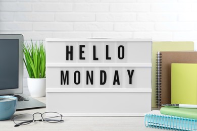 Light box with message Hello Monday, office stationery and laptop on desk