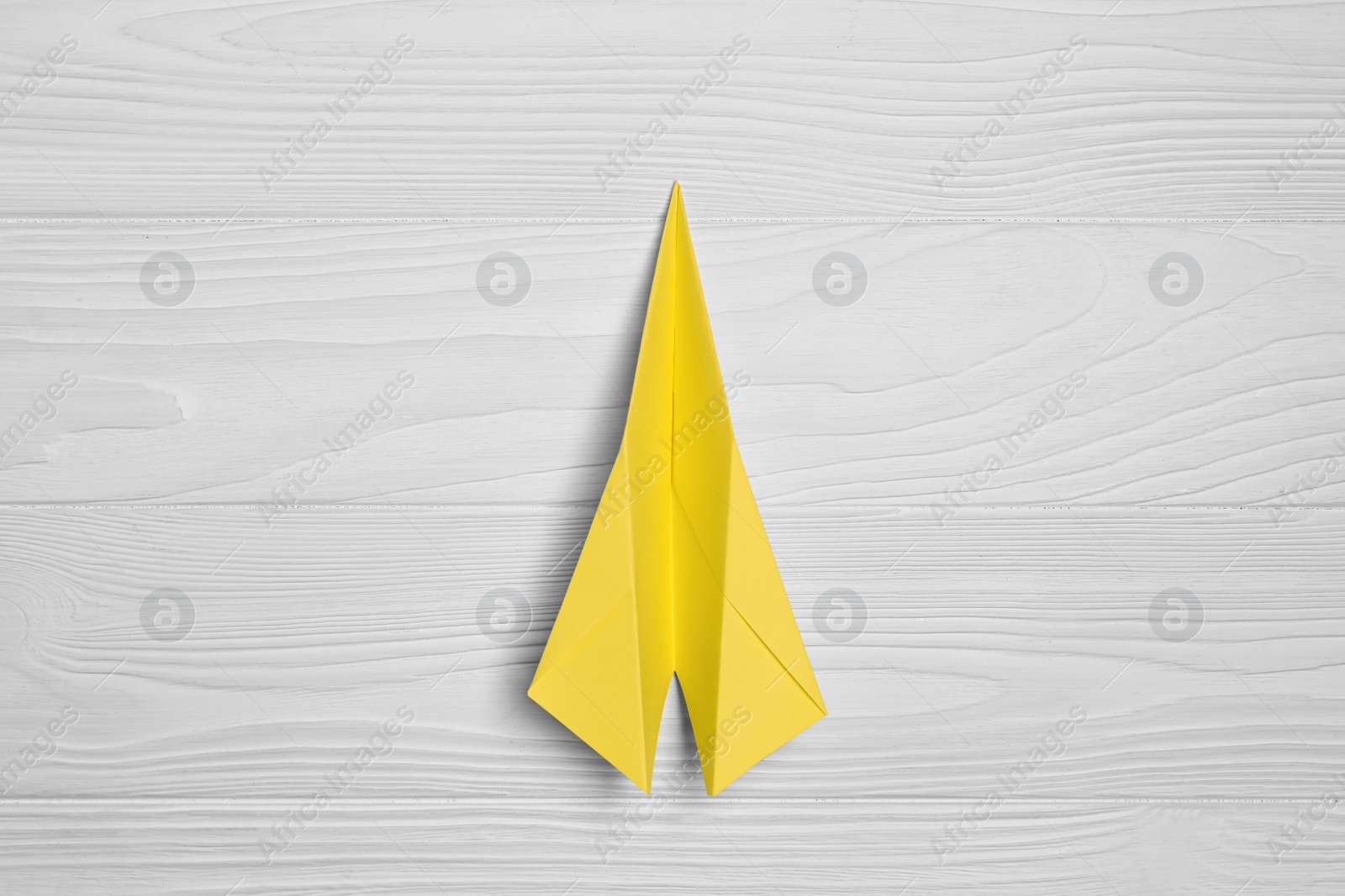 Photo of Handmade paper plane on white wooden table, top view