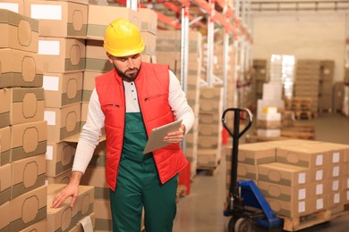 Image of Man with tablet working at warehouse. Logistics center