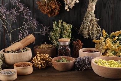Photo of Many different dry herbs and flowers on wooden table