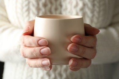 Woman holding cup of hot winter drink, closeup