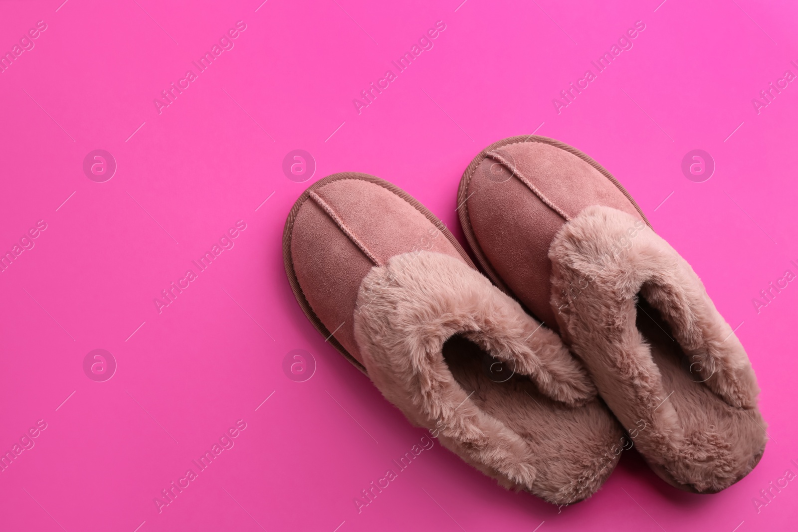 Photo of Pair of stylish soft slippers on pink background, flat lay. Space for text